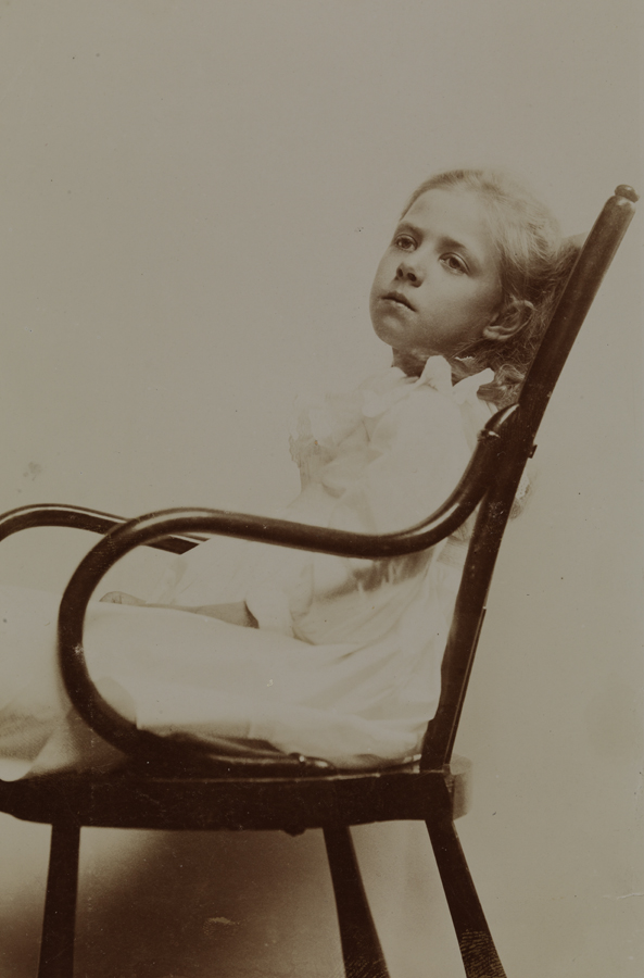 Unidentified girl, sitting in chair, facing left