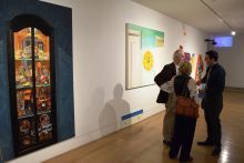 Three people conversing in the gallery