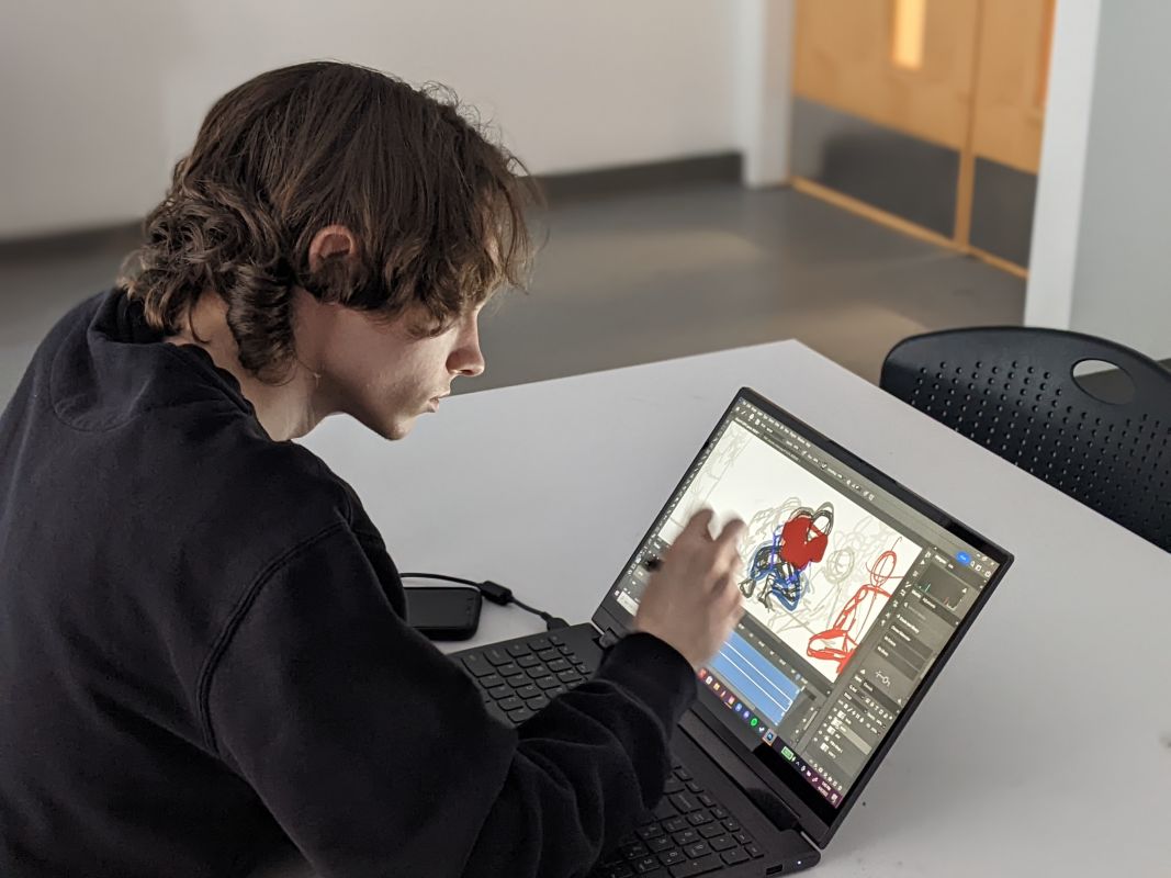 student drawing on laptop screen