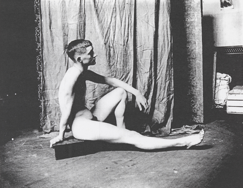 Bill Duckett nude, sitting on a small wooden pedestal