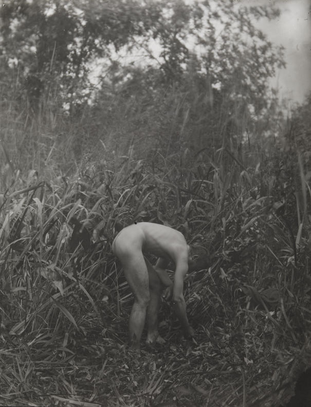 Thomas Eakins nude, bending over , left arm on knee, in tall grass