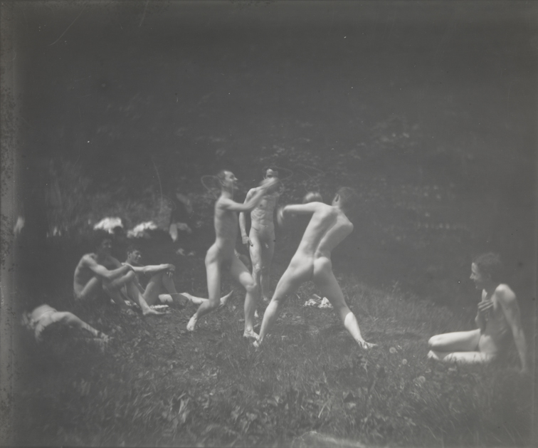 Seven males, nude, two boxing and one standing at center