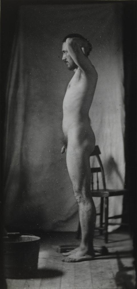 Naked series: Thomas Eakins with chair in front of cloth backdrop, pose 1