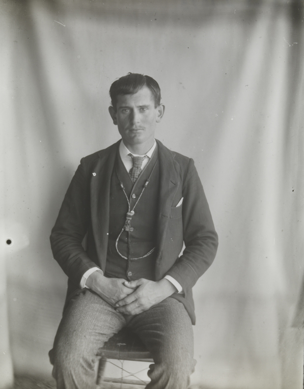 Man sitting in front of draped background