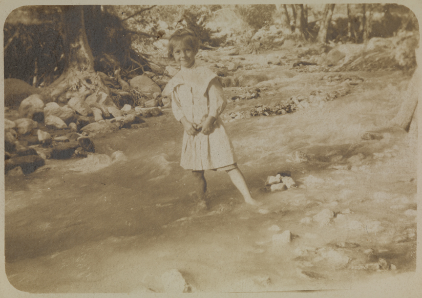 Girl wading in stream