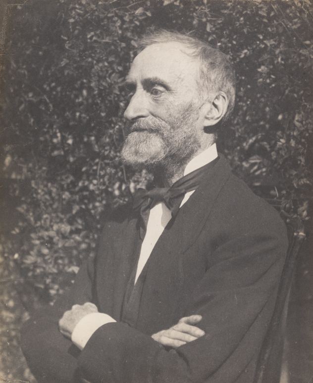 George W. Holmes, facing left, arms folded