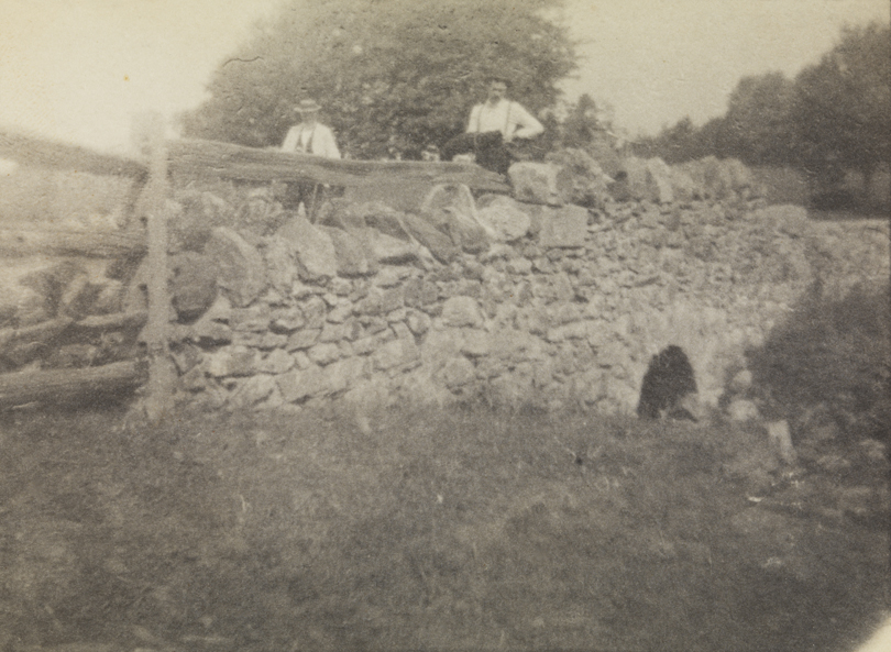 Benjamin Eakins and Samuel Murray with bicycles on stone bridge                     