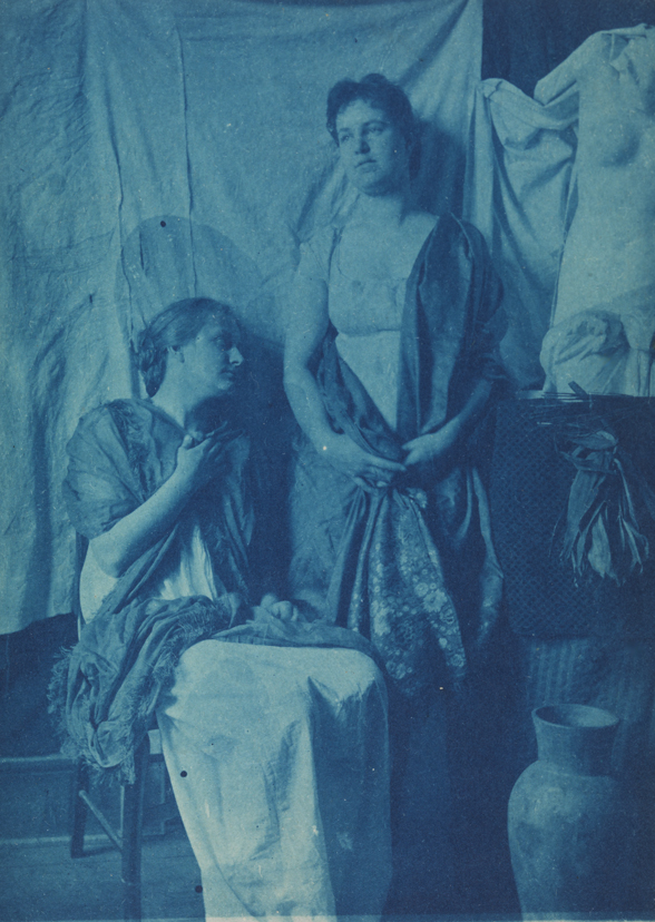 Two women in classical costume, wearing shawls, with Venus torso