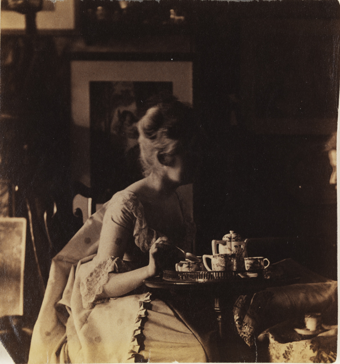 Woman in eighteenth-century costume, sitting at tea table