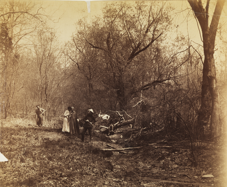 Seven men in theatrical costume in woods