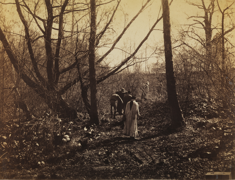 Six men in theatrical costume in woods