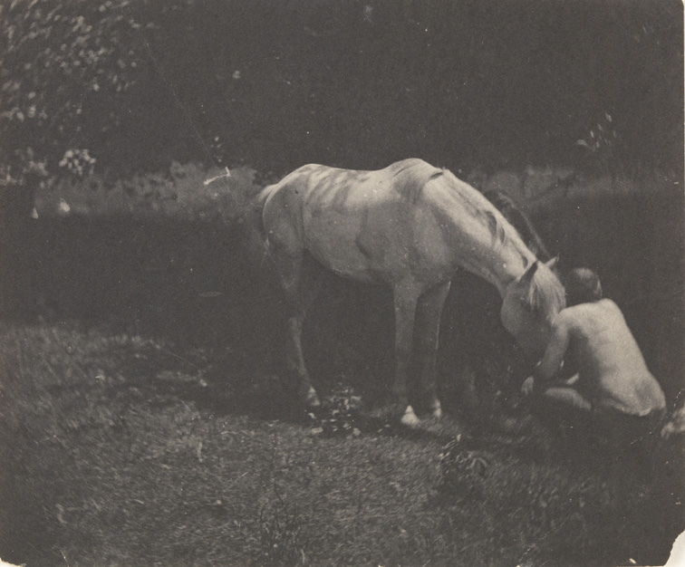 Thomas Eakins crouching in front of his horse Billy