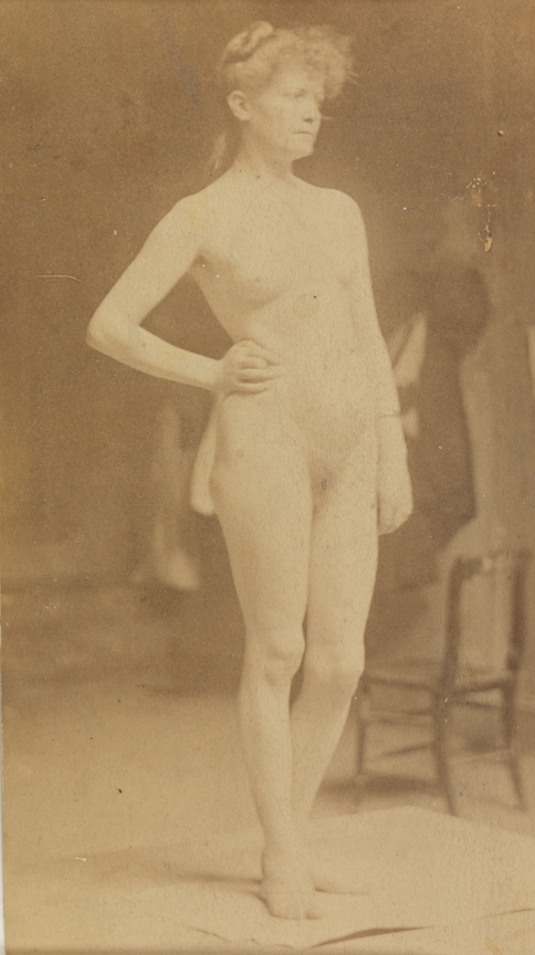 Female nude, facing right, right hand on hip, left leg bent