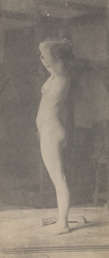 Female nude with black mask, facing left, hands clasped behind head