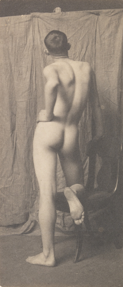 Bill Duckett nude, leaning against chair, from rear