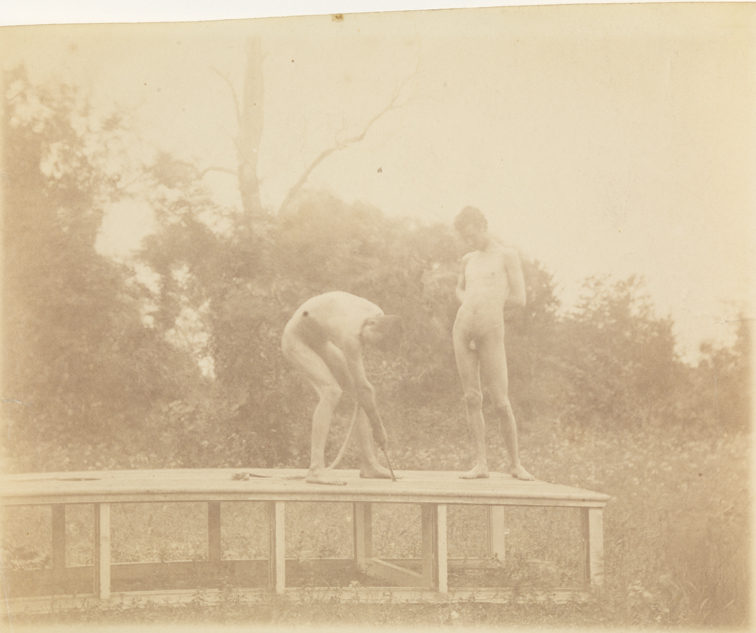 Male nude and J. Laurie Wallace nude on platform in wooded landscape