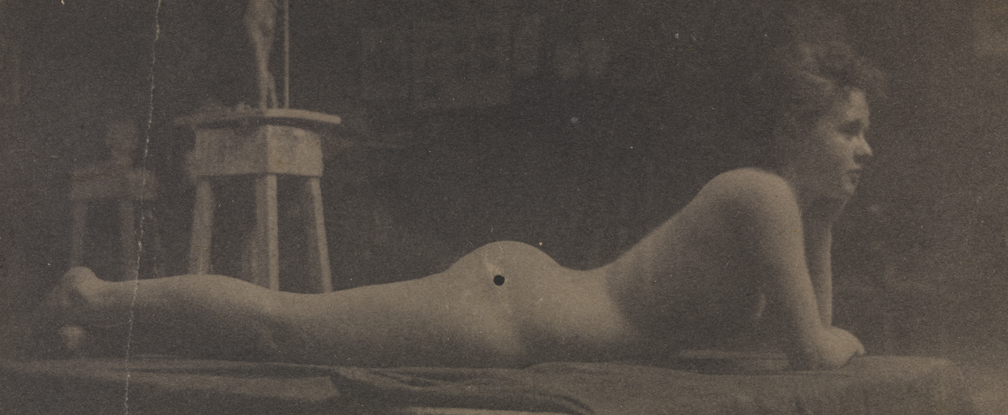 Female nude lying on stomach, head on hand