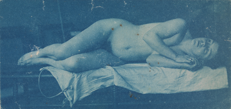 Female nude reclining on left side on bench