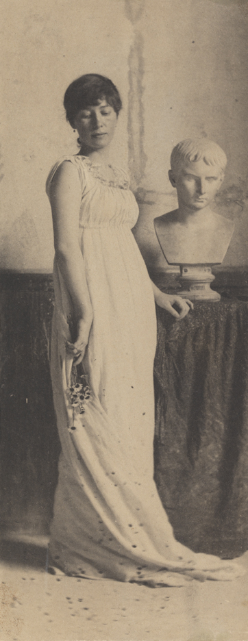 Woman in classical costume, holding flowers, with bust of Caesar