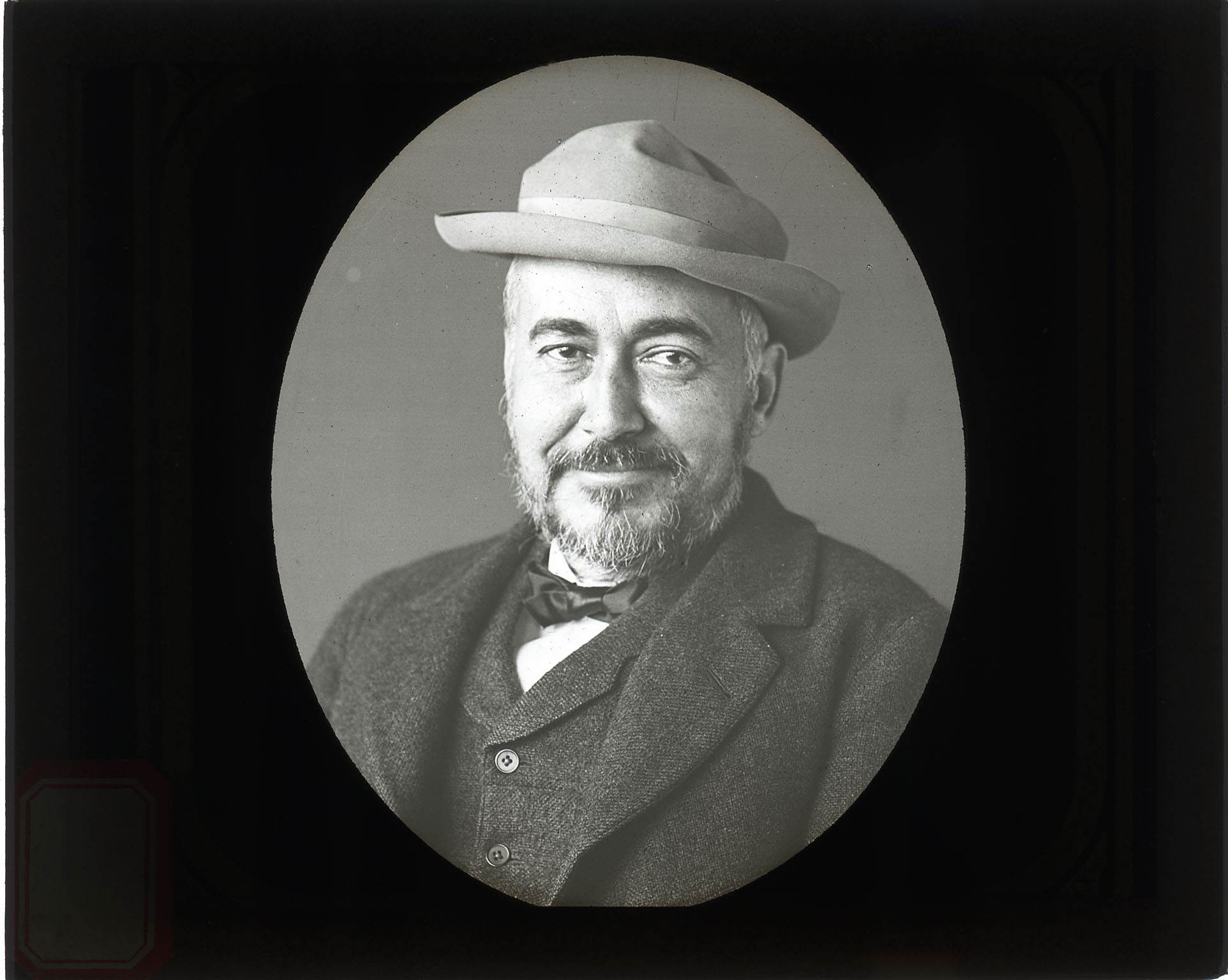 Thomas Eakins, sitting, smiling,  wearing hat