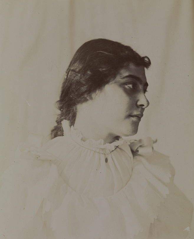 Unidentified young woman in light dress, facing right