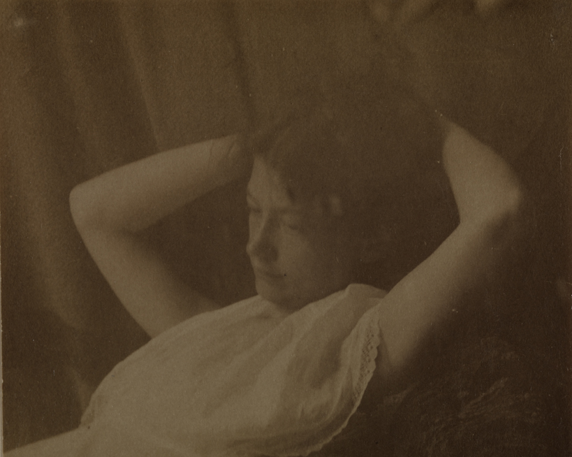 Mary Macdowell in sleeveless dress, leaning back, hands behind head