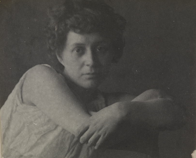 Cecil Boulton in sleeveless dress, arms crossed over back of chair