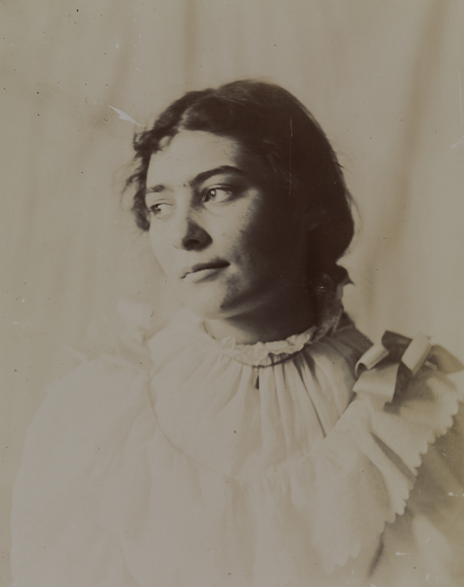 Unidentified young girl in light dress, looking left