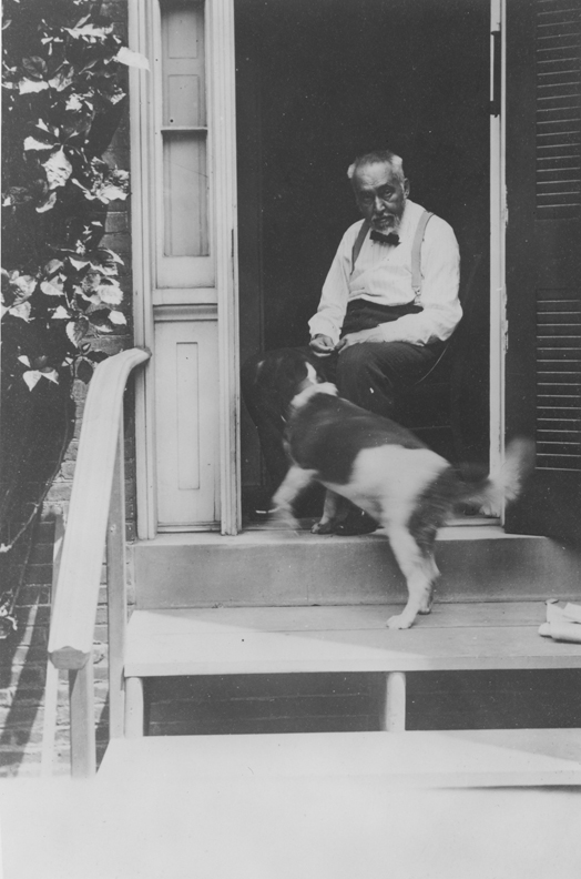 Thomas Eakins with his dog in doorway of the family home at 1729 Mount Vernon Street, Philadelphia