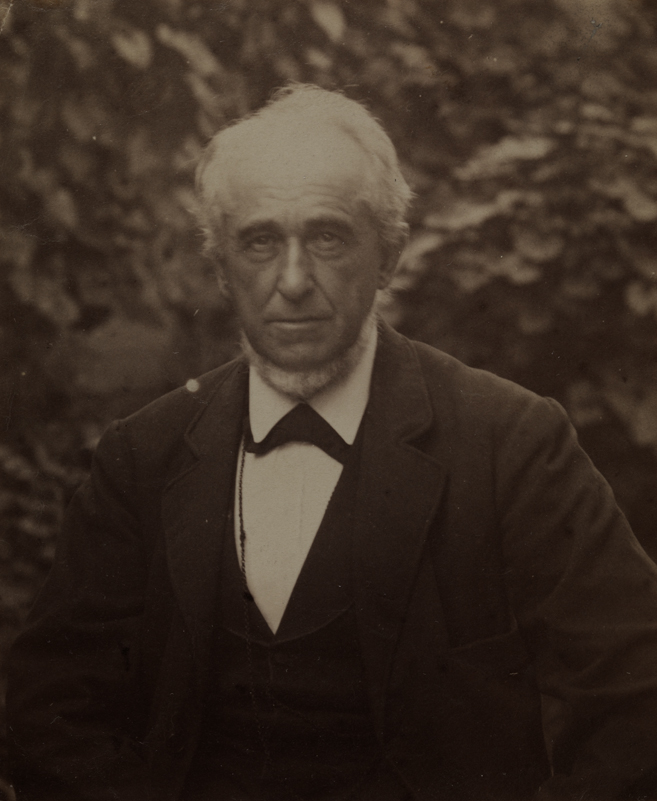 Benjamin Eakins in dark suit, sitting in yard of the family home at 1729 Mount Vernon Street, Philadelphia