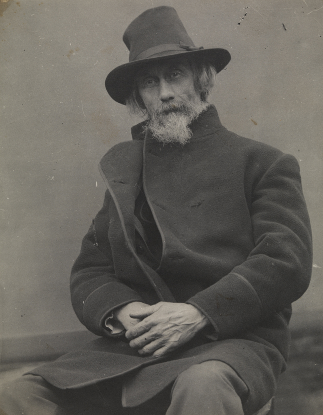 William H. Macdowell in coat and hat, sitting
