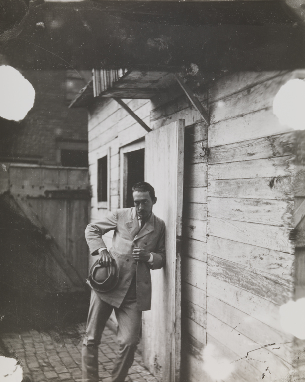 Thomas Eakins leaning against building