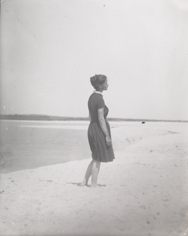 Mary Macdowell standing in profile at shoreline          