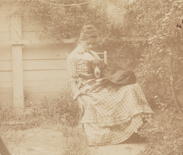 Susan Macdowell sitting with setter in yard