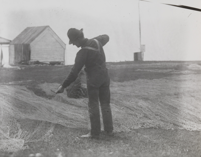 Two fishermen mending nets