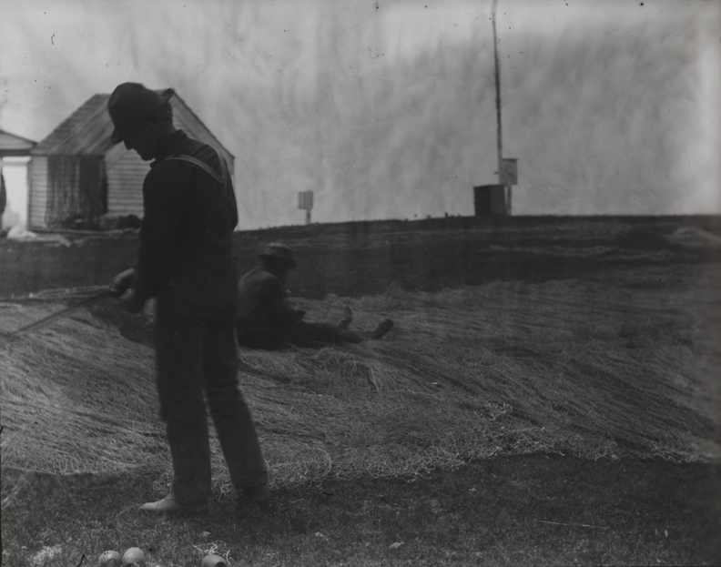 Two fishermen mending nets