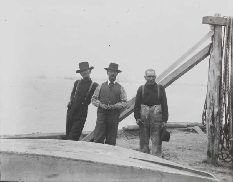 Three fishermen standing at edge of Delaware River