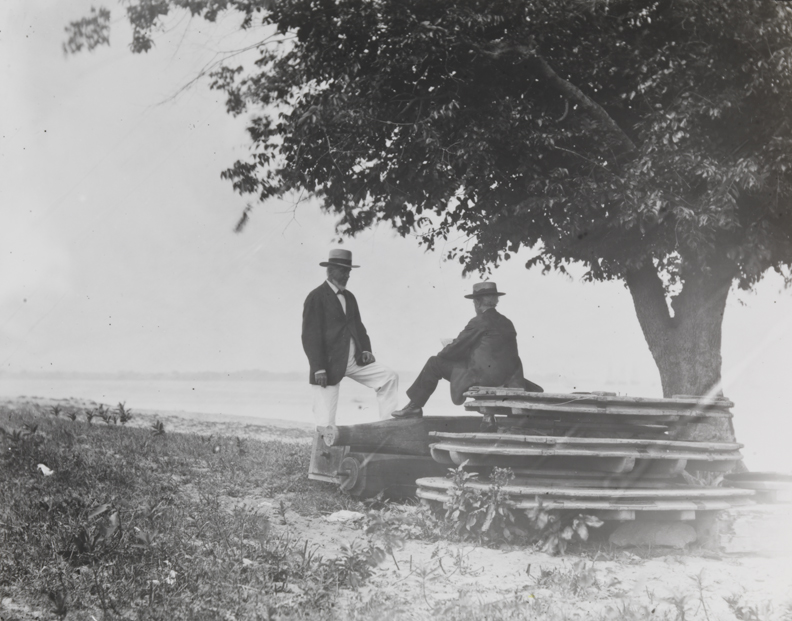 Benjamin Eakins standing and man sitting, under tree near Delaware River