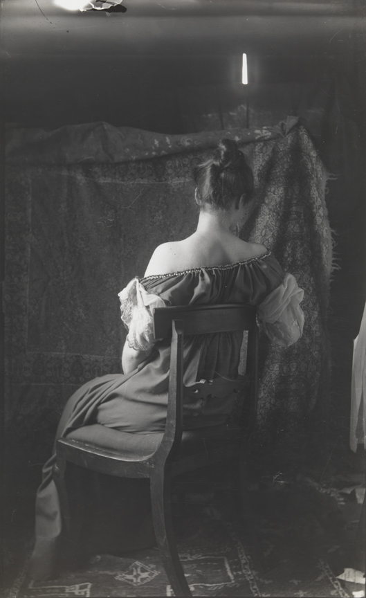 Clara Mather sitting in Empire chair, rear view