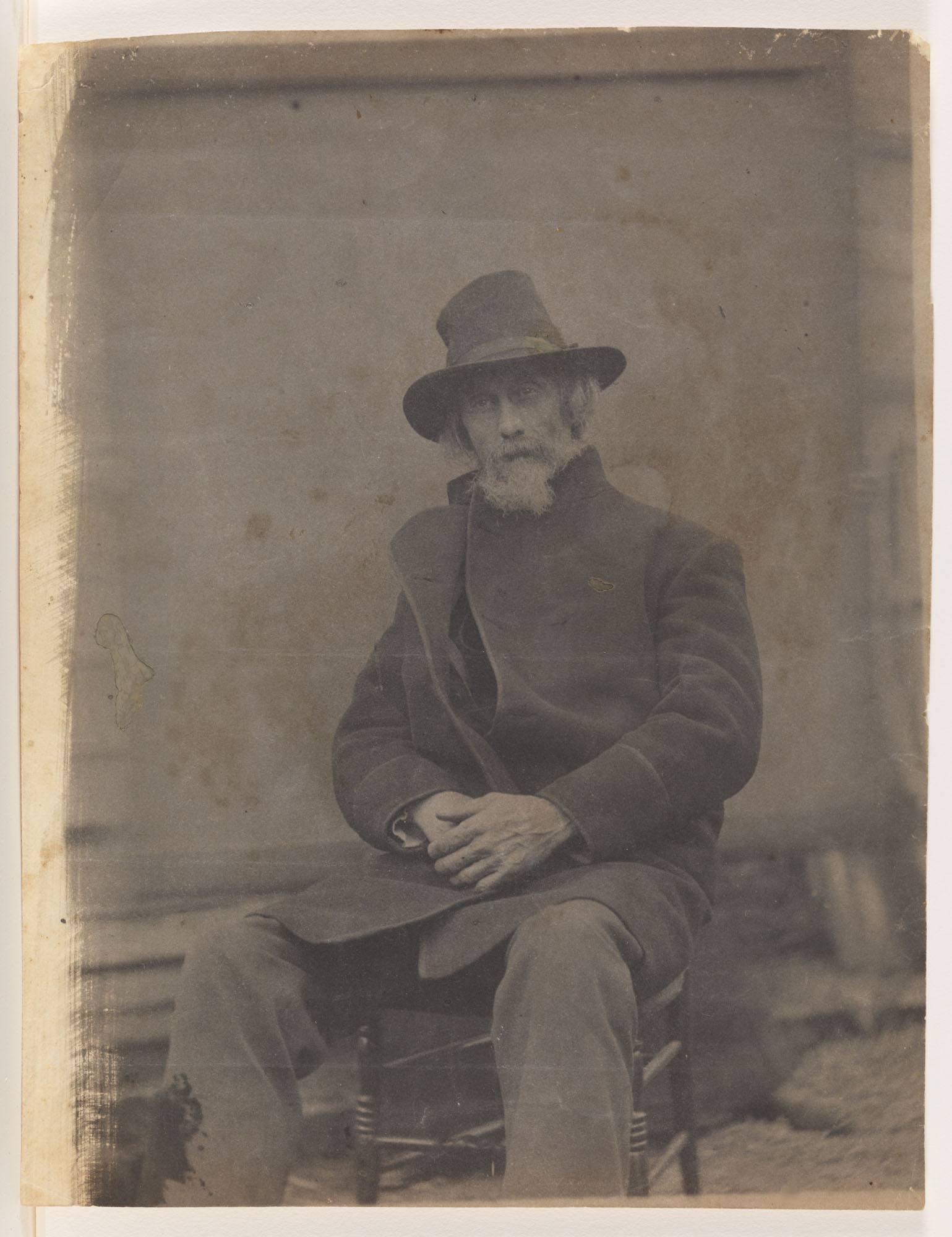 William H. Macdowell in coat and hat, sitting