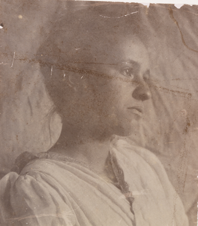 Unidentified woman sitting, looking right