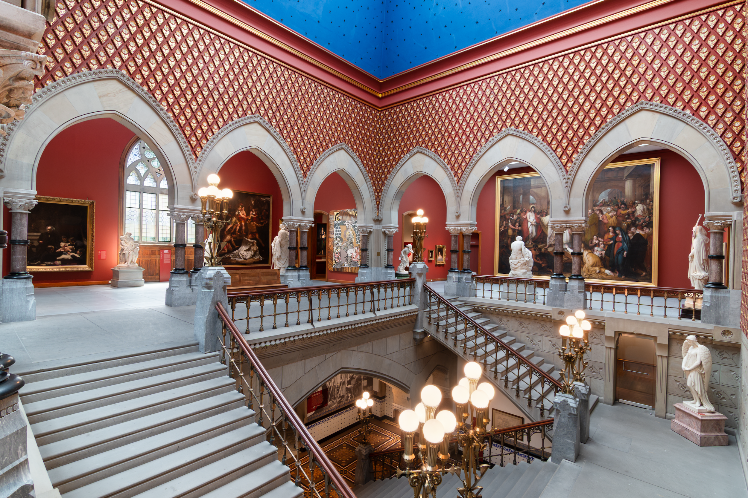 the historic Frank Furness-designed Victorian Gothic interior of the Pennsylvania Academy of the Fine Arts (PAFA) Landmark Building in Philadelphia, featuring polychrome brickwork, pointed arches, and a star-studded blue ceiling.