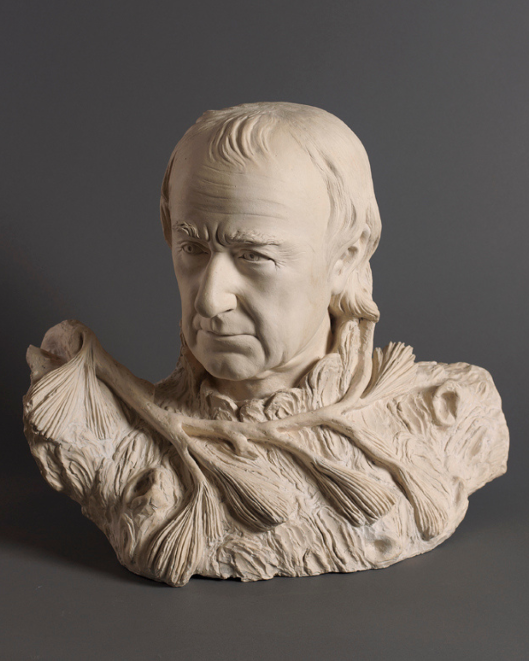 A terracotta self-portrait by American neoclassical sculptor William Rush (ca. 1822) depicts a middle-aged man emerging from a base of rough-hewn wood and pine branches.