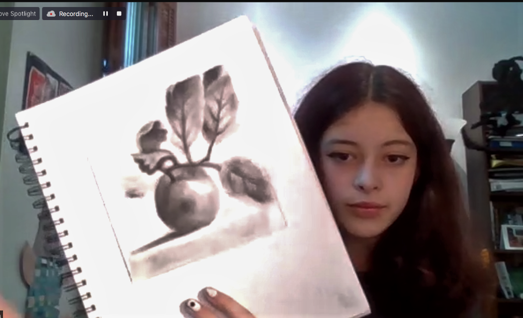 student showing her drawing via zoom