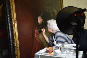 Mary McGinn, PAFA’s Paintings Conservator, working on Charles Wilson Peale's The Artist in His Museum.