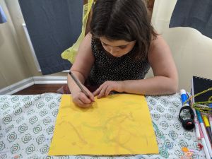 child drawing at her desk