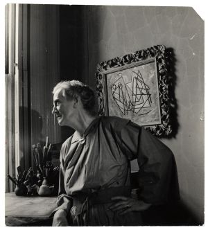 Black and white photo of Anne Ryan in her New York Studio looking out a window. 