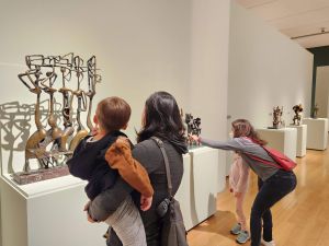 adults and children looking at sculpture