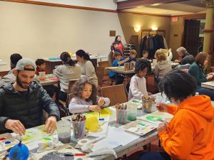 kids and adults making art in an auditorium.