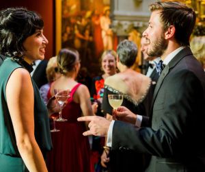 People standing in an art gallery talking.